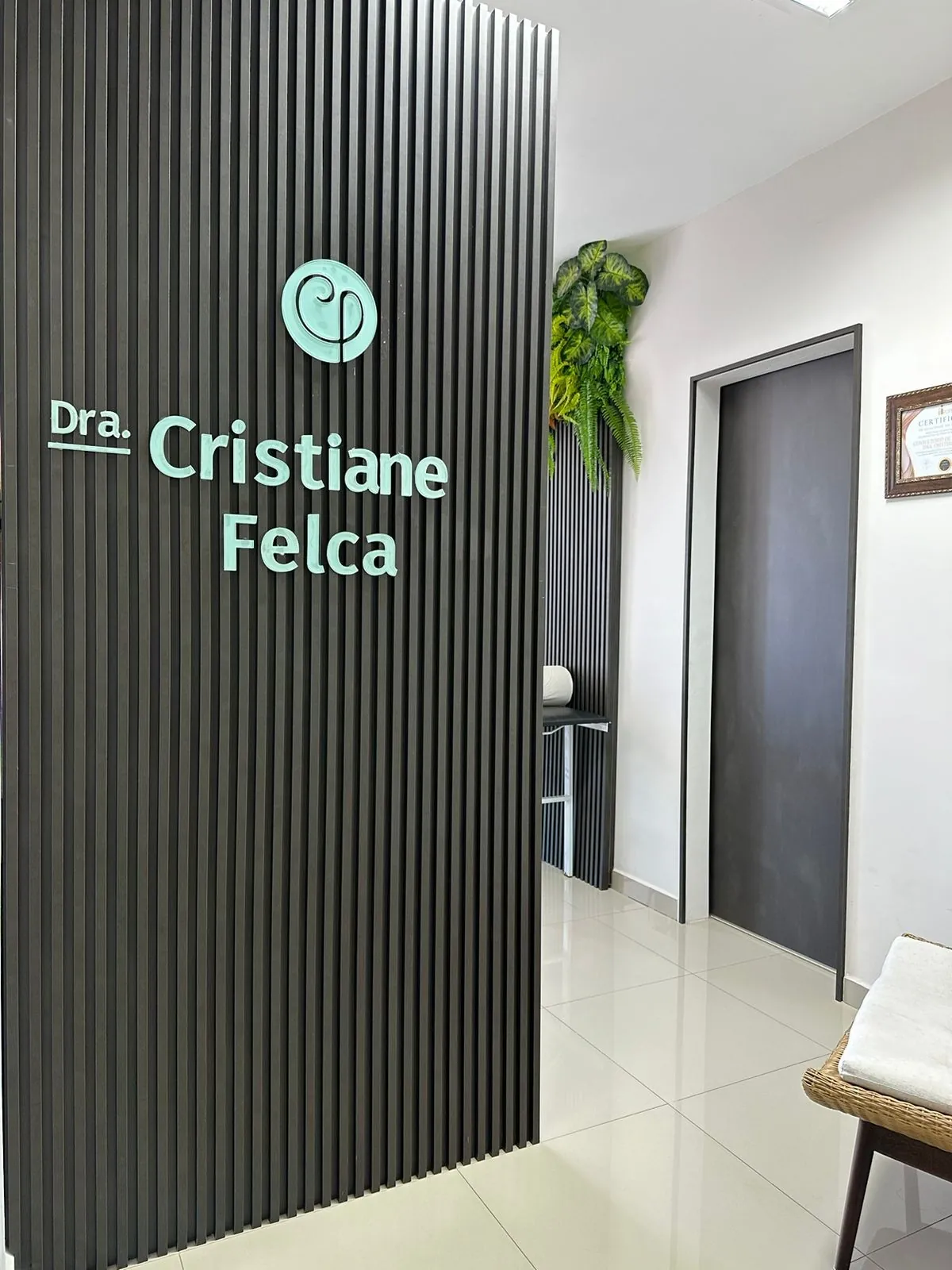 Parede com o nome da Dra. Cristiane Felca na entrada do consultório